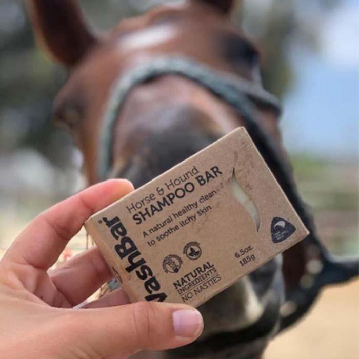 Hand holding WashBar Horse & Hound Shampoo Bar next to horse’s muzzle – natural, zero‑waste equine grooming soap