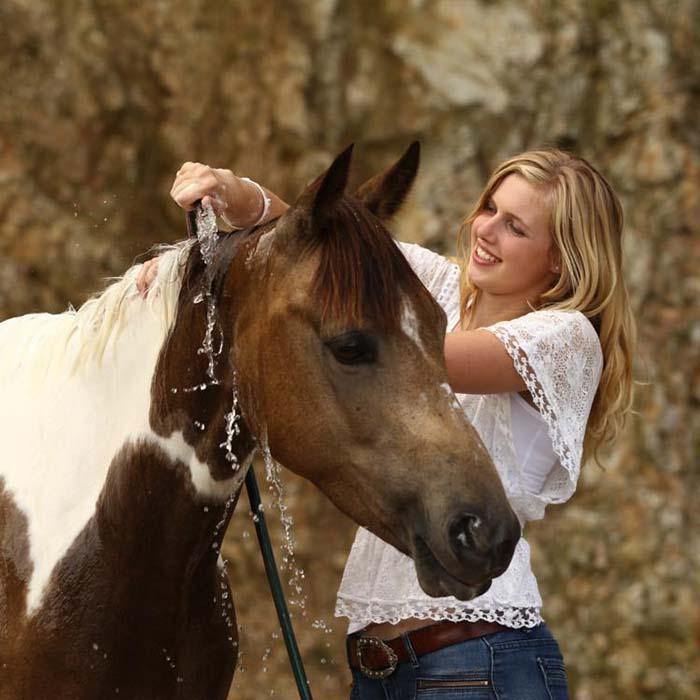 Woman rinsing suds off horse after using WashBar Horse & Hound Shampoo Bar – sustainable grooming without plastic bottles